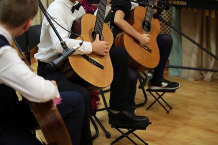 Drei Kinder, die im Anzug Gitarre spielen