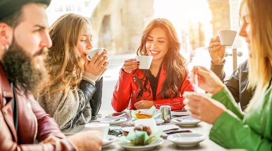 3 Frauen und Ein Mann sitzen am Tisch und trinken Kaffee