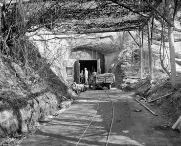 Mit einem Tarnnetz überspannter Eingang der sogenannten Aero-Stahl-Grube im März 1945 bei der Begutachtung durch US-Truppen.