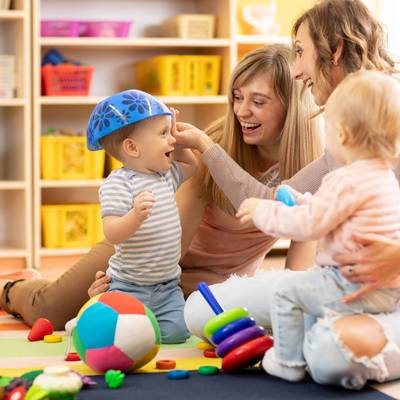 Kinder spielen mit Erzieherinnen