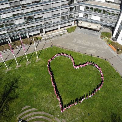 Mitarbeiter des Kreises, die Bürgermeisterinnen und Bürgermeister stehen in einem Herz und tragen pinke Shirts