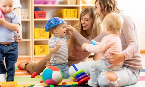 Kinder spielen mit Erzieherinnen