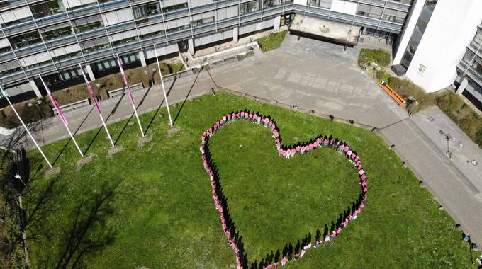 Mitarbeiter des Kreises, die Bürgermeisterinnen und Bürgermeister stehen in einem Herz und tragen pinke Shirts